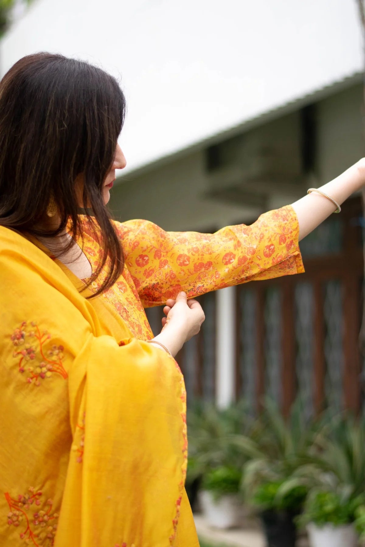 A woman's grace is complemented by a beautiful yellow Chanderi Kurta.