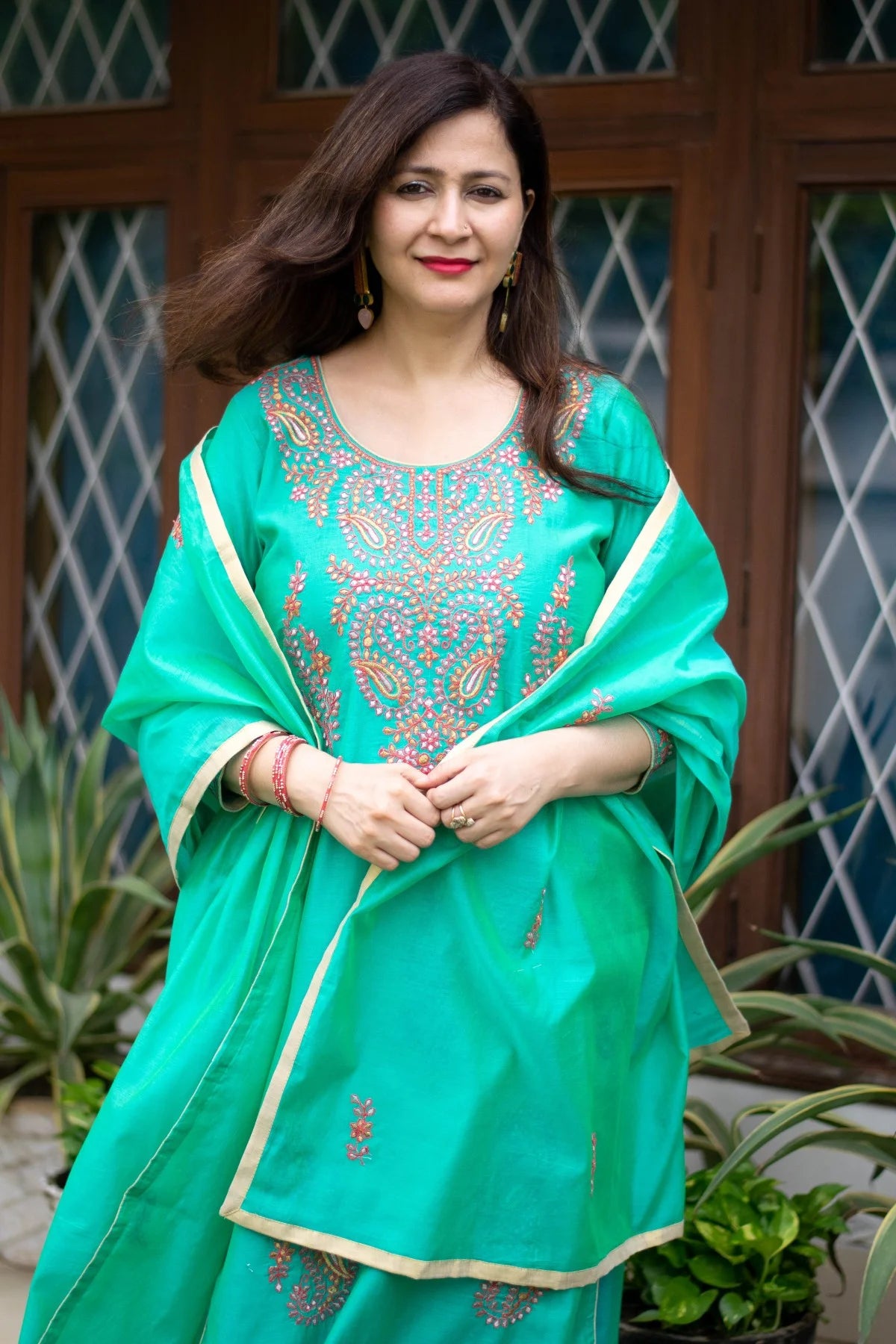 A traditional Indian outfit consisting of a sea green zari kurta and matching leggings.