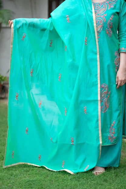 A stylish sea green zari kurta paired with contrasting red churidar pants.