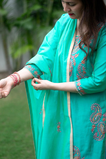 A woman showcasing a sea green zari kurta with delicate detailing.