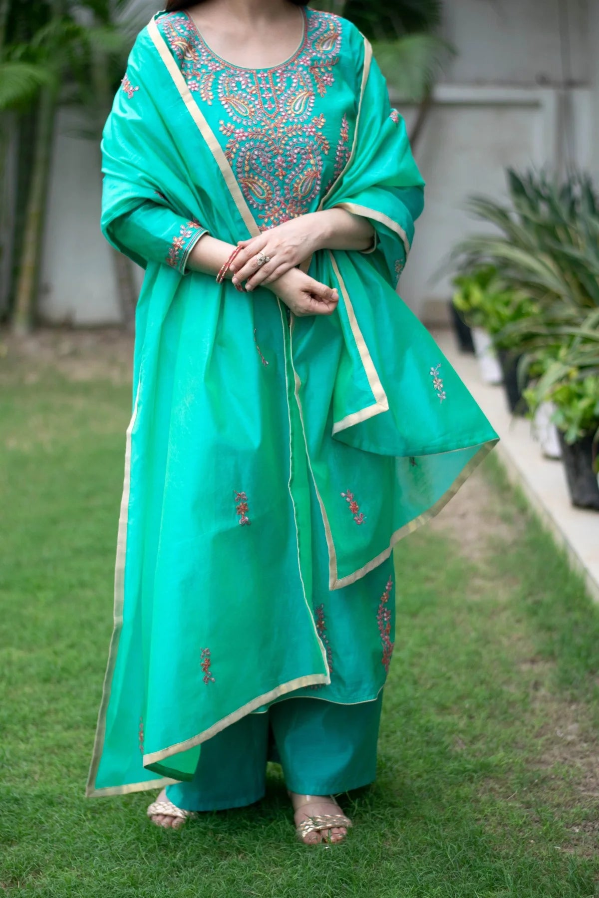 A sea green zari kurta with a pleated hemline and matching dupatta.