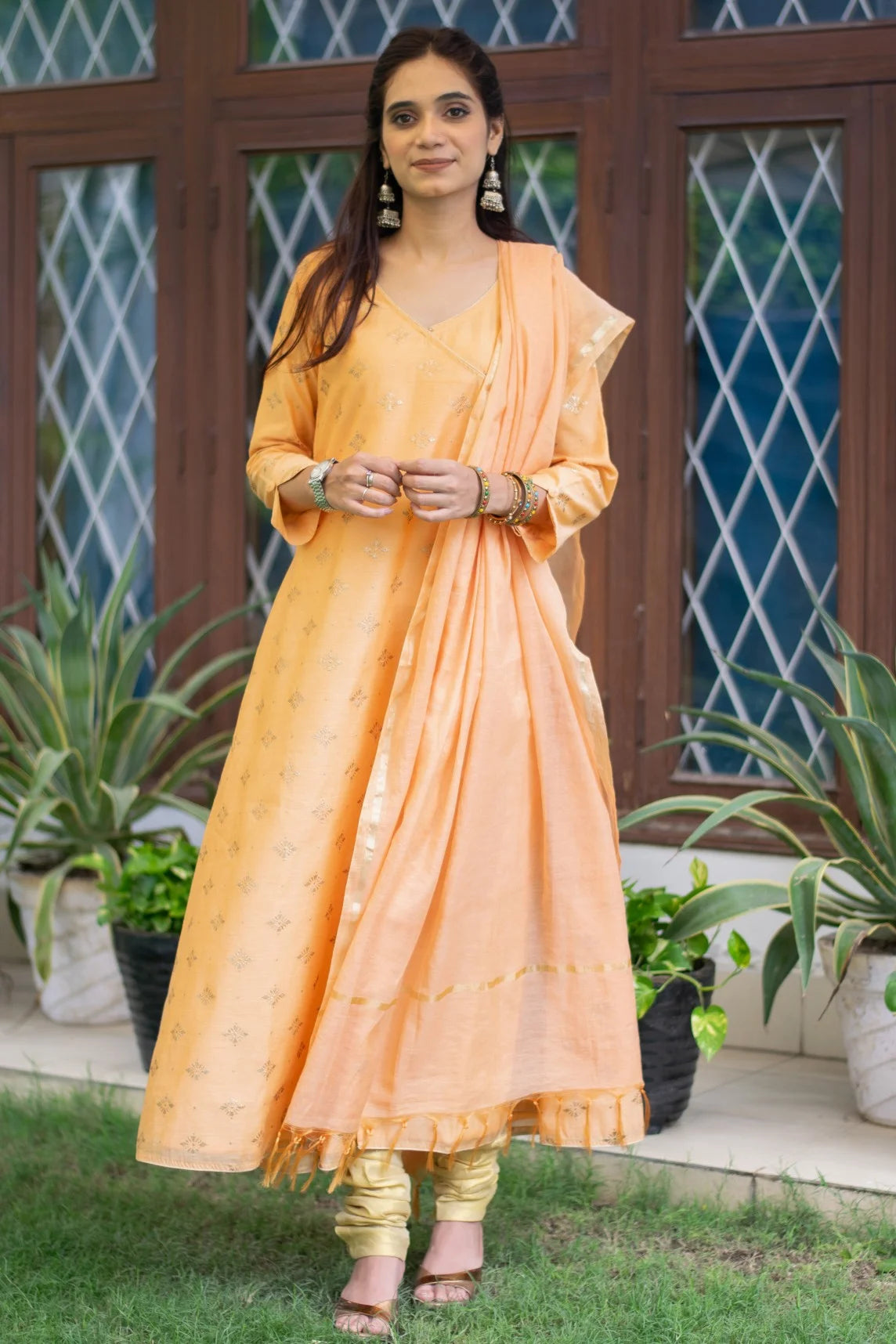 A stunning peach angarkha kurta worn by an Indian woman, showcasing traditional craftsmanship.