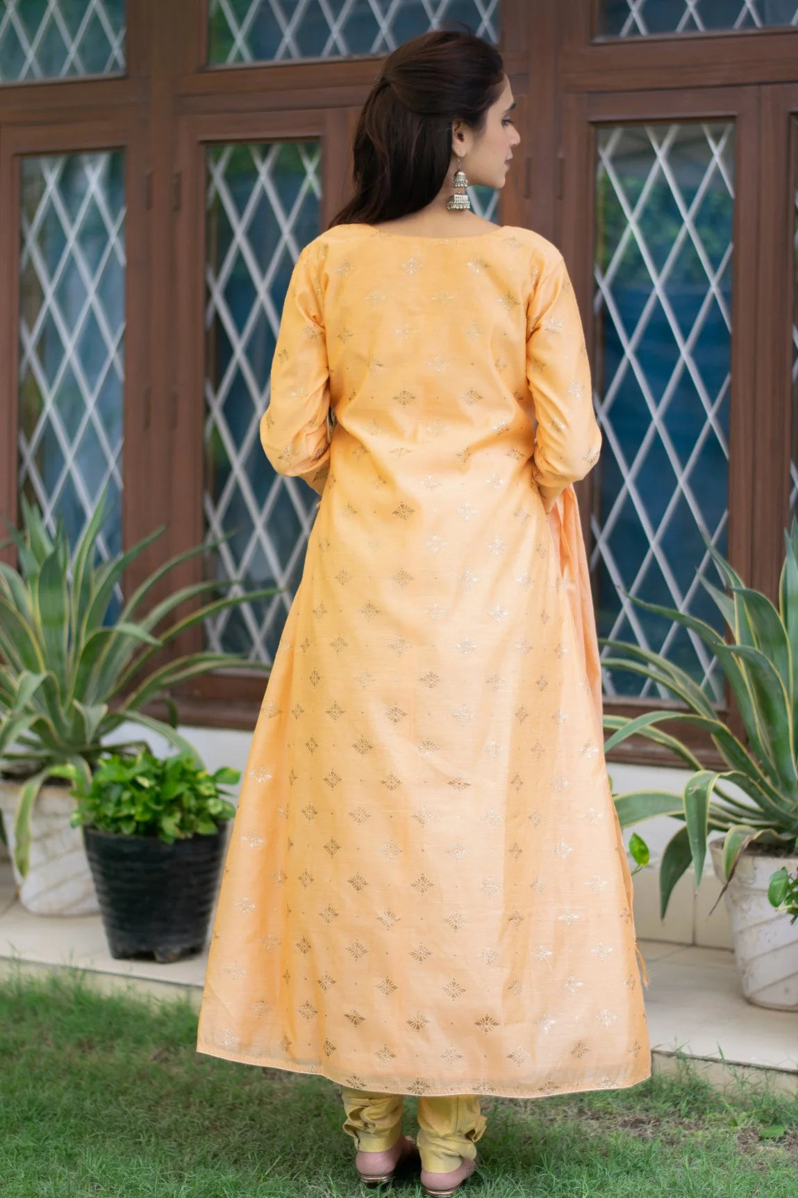 A beautifully crafted peach angarkha kurta, worn by an Indian woman, highlighting the exquisite embroidery.