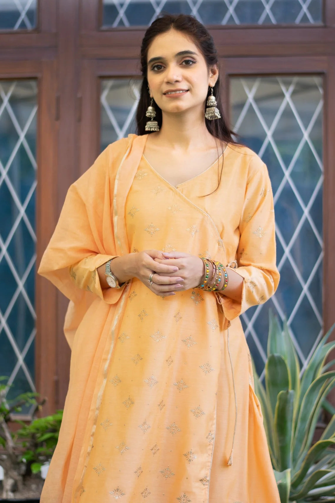 Indian women wearing Peach angarkha style kurtaAn Indian woman wearing a beautiful peach angarkha kurta with intricate embroidery.