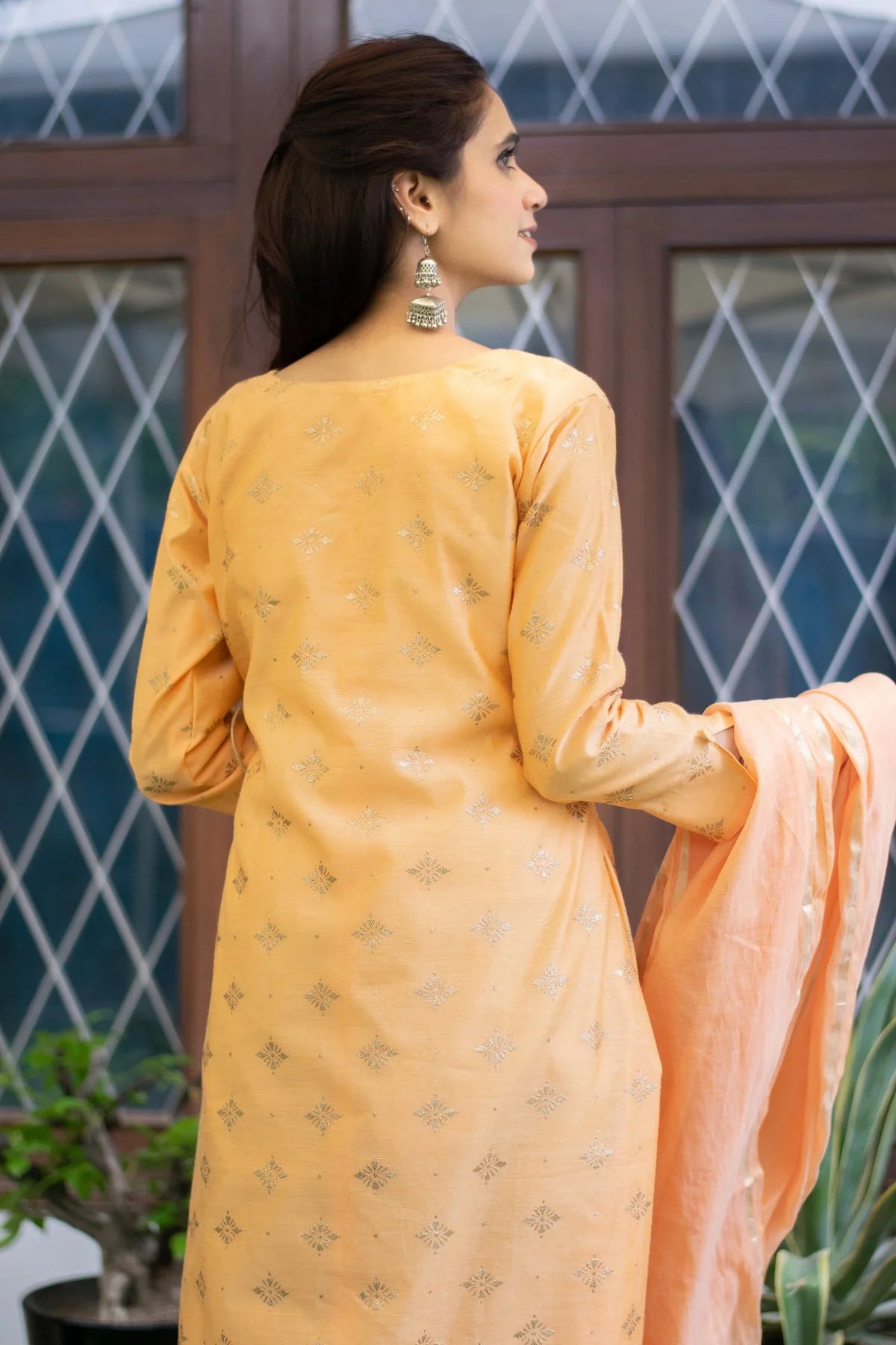 A stylish and sophisticated peach angarkha kurta, adorning an Indian woman.