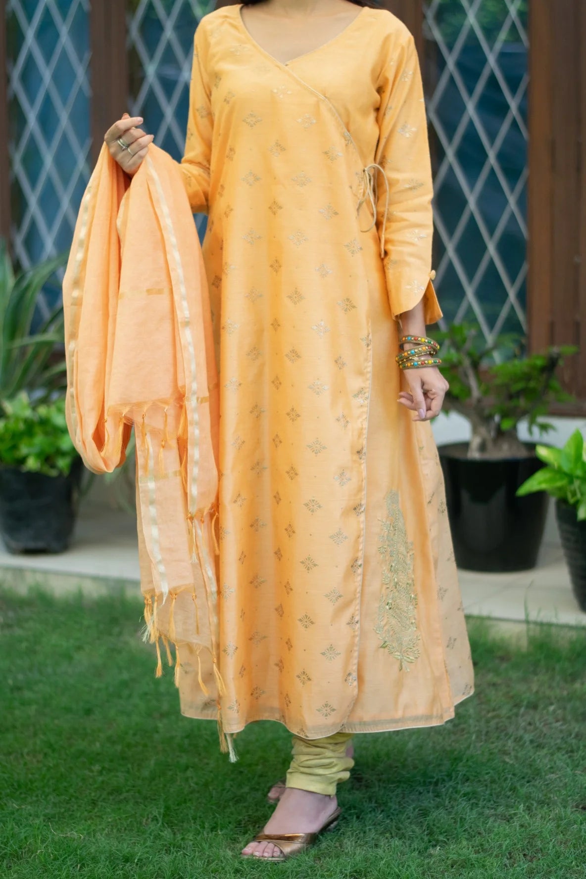 A lovely peach angarkha kurta, adorned with intricate embroidery, as worn by a graceful Indian woman.