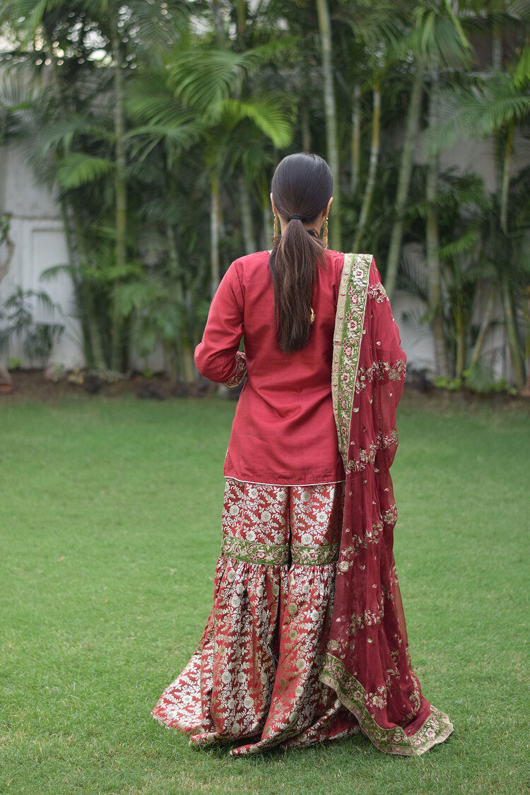 Woman wearing elegant Maroon Silk & Kamkhab Tilla Embroidered Gharara set with grace
