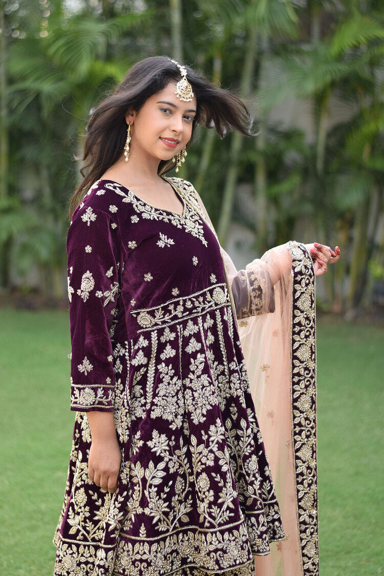 A stunning ensemble featuring a wine velvet lehenga set with intricate gold embroidery and Zardozi work.