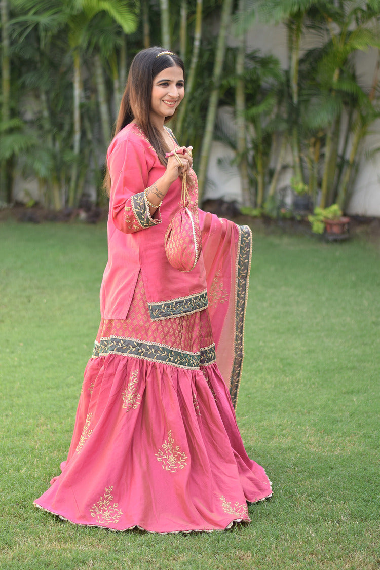 A stunning fuchsia pink Chanderi Gharara set adorned with intricate Aari and tissue applique work on a gorgeous lady.