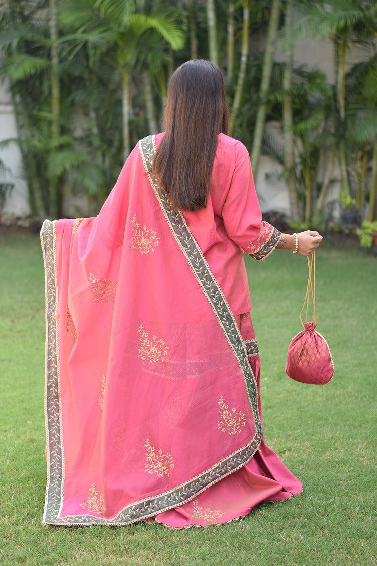 A lady looks radiant in her fuchsia pink Chanderi Gharara set with stunning Aari and tissue applique work.