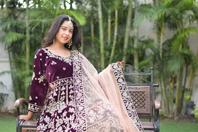 A stunning bridal outfit in wine velvet adorned with intricate Zardozi work, perfect for a grand celebration.