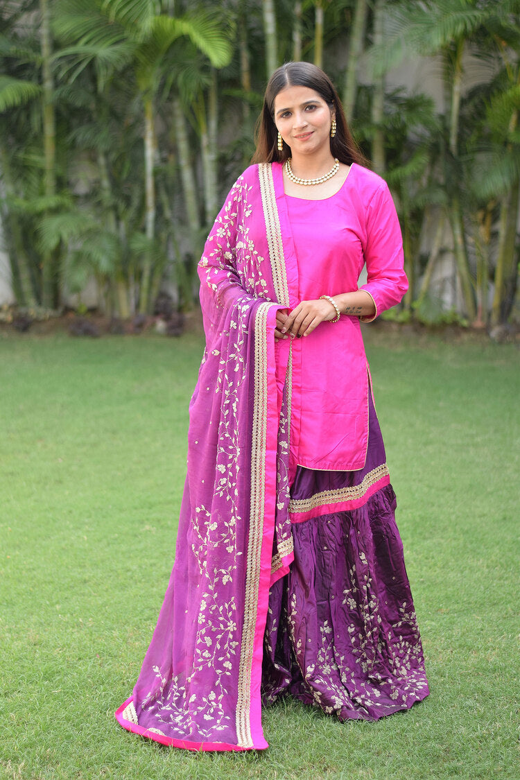 A woman wearing a stunning Purple and Magenta Silk Applique Gharara set.
