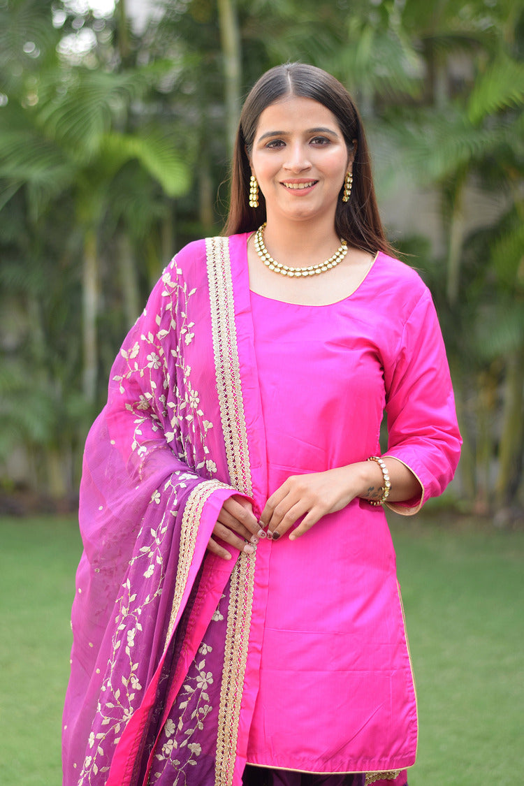 A woman looking stunning in her Purple and Magenta Silk Applique Gharara set.