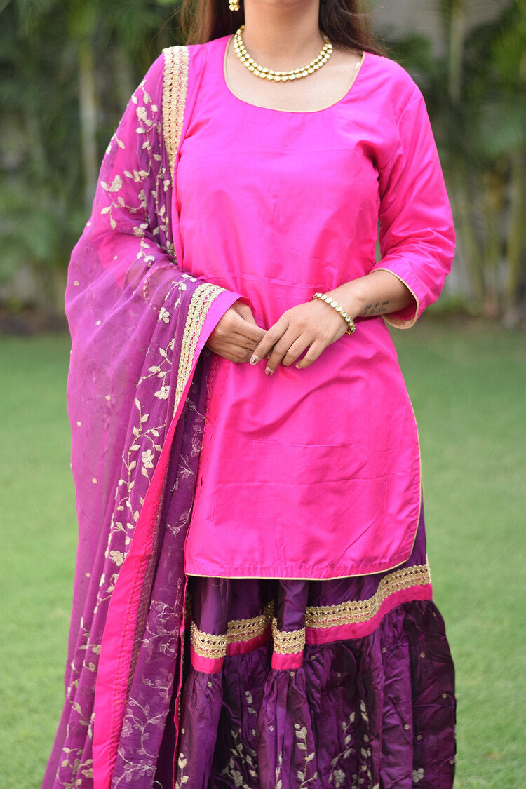 A lady in a regal Purple and Magenta Silk Applique Gharara set.