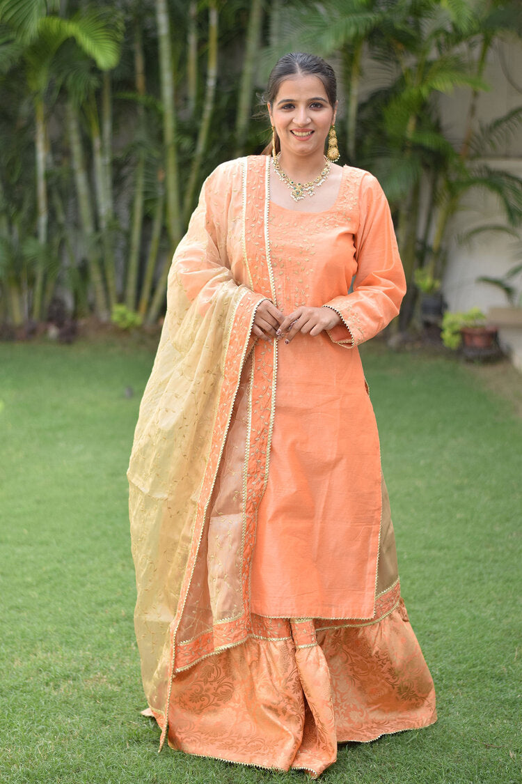 A woman wearing a Peach Kamkhab Farshi Gharara, Peach Chanderi Kurta & Golden Dupatta with Tissue Applique Work