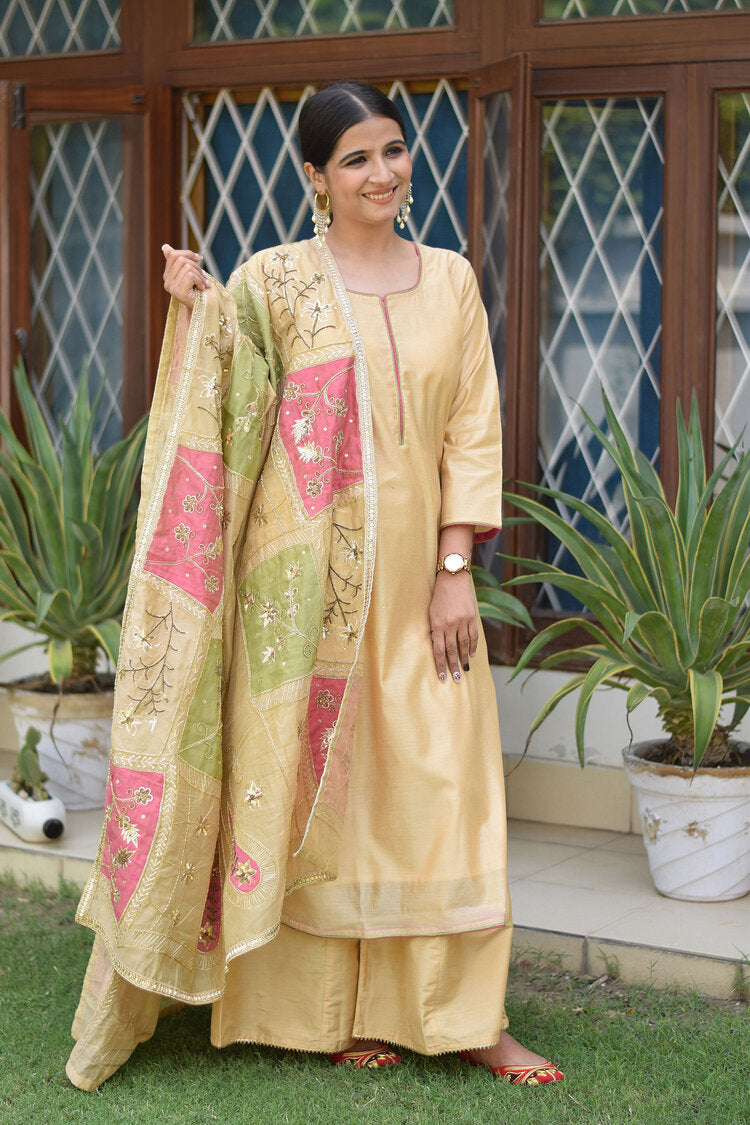 A stunning outfit featuring a pink and green patchwork Chanderi dupatta draped over a golden kurta and palazzo pants.