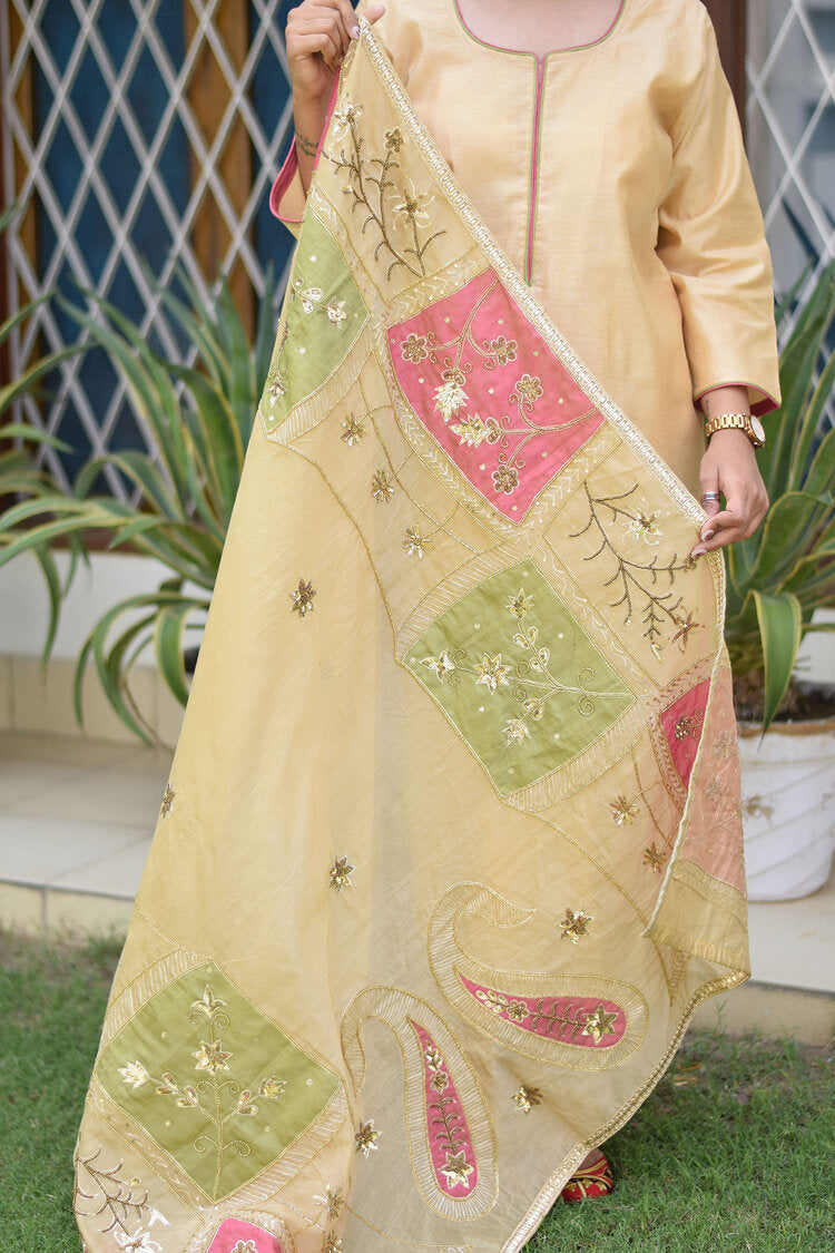 A vibrant outfit with a pink and green patchwork Chanderi dupatta, paired with a golden kurta and palazzo pants.