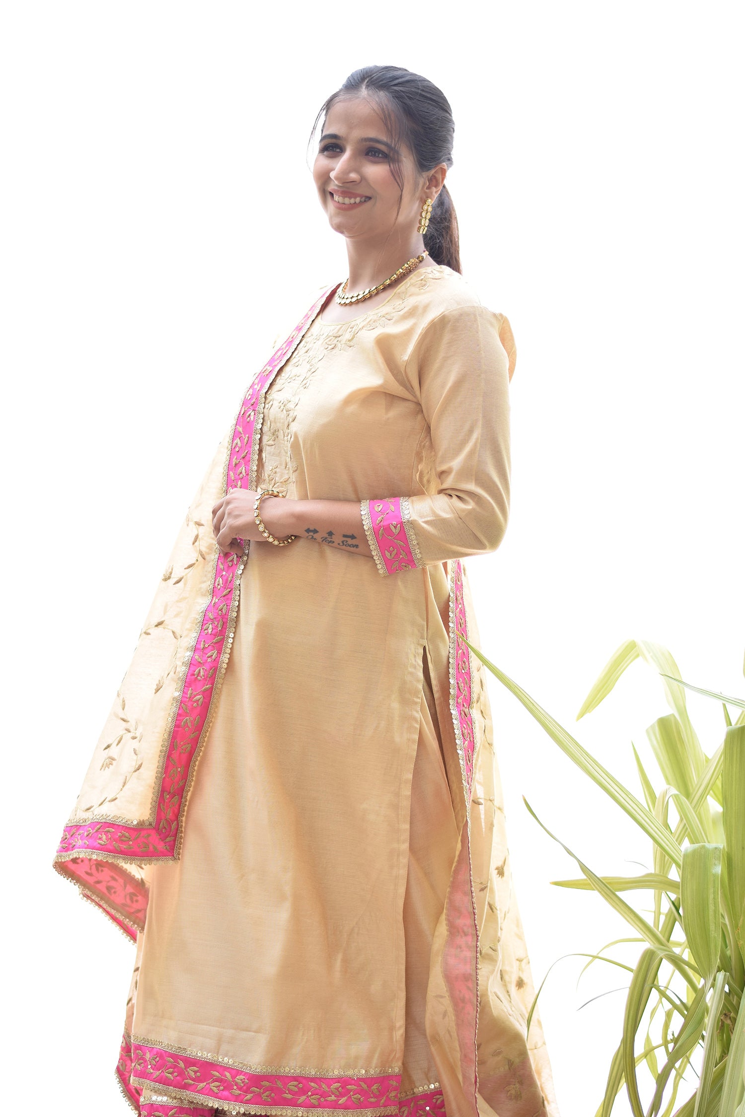 A lady dressed in a captivating Magenta Kamkhab Farshi Gharara, Golden Chanderi Kurta & Dupatta with Tissue Applique Work.