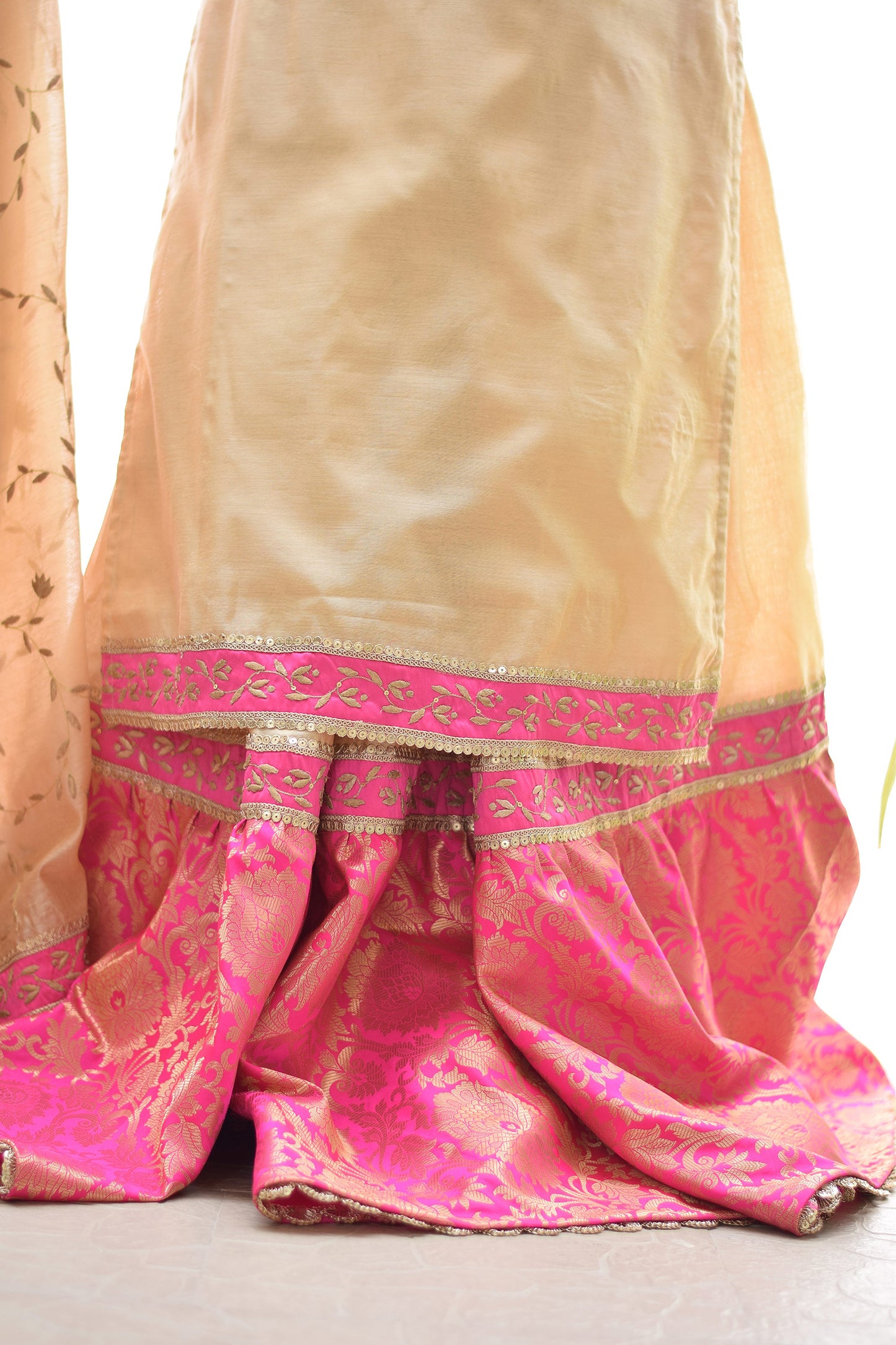 An outfit that features a Magenta Kamkhab Farshi Gharara, Golden Chanderi Kurta & Dupatta with Tissue Applique Work, worn by a confident woman.