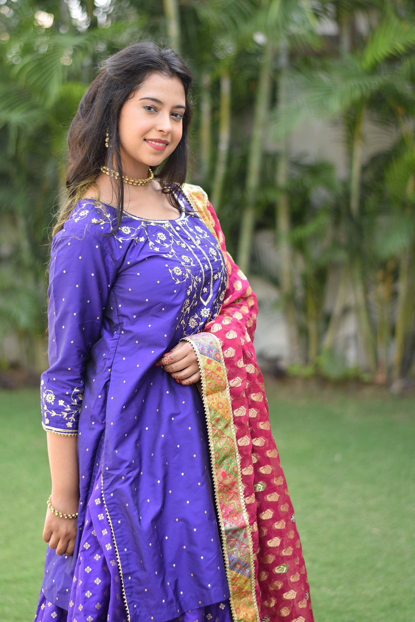 An Indian Girl posing sideways wearing Purple Silk & Multicolored Brocade Farshi Gharara Set