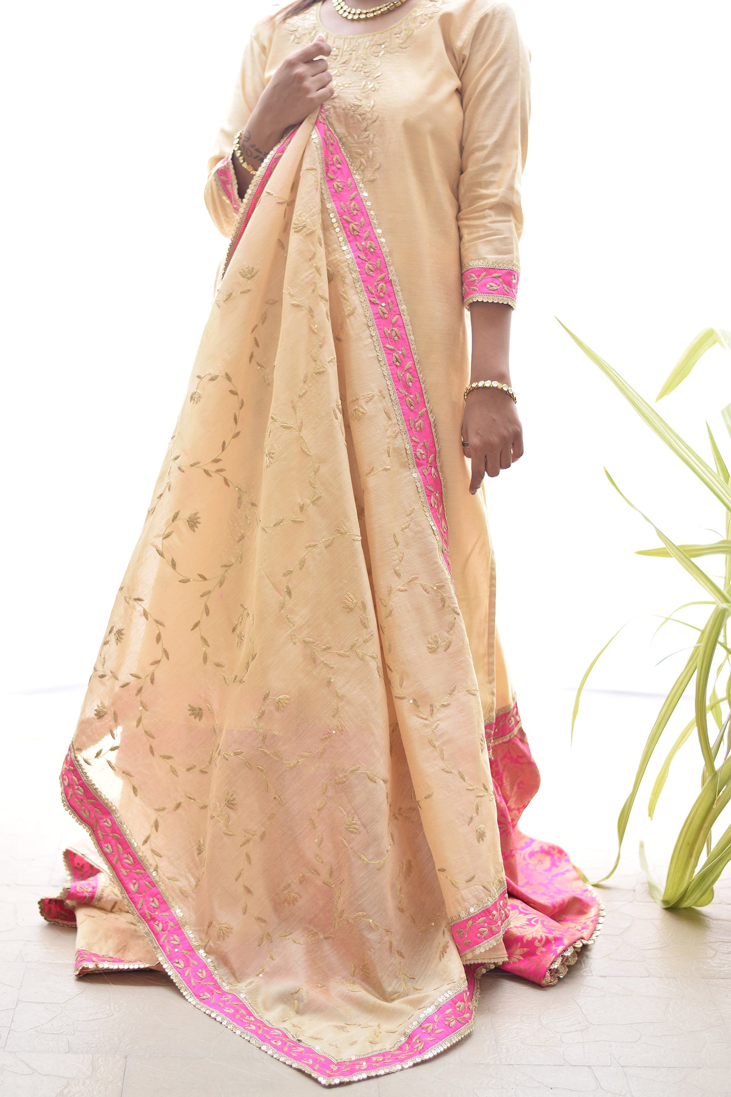 A woman flaunting a striking Magenta Kamkhab Farshi Gharara, Golden Chanderi Kurta & Dupatta with Tissue Applique Work.