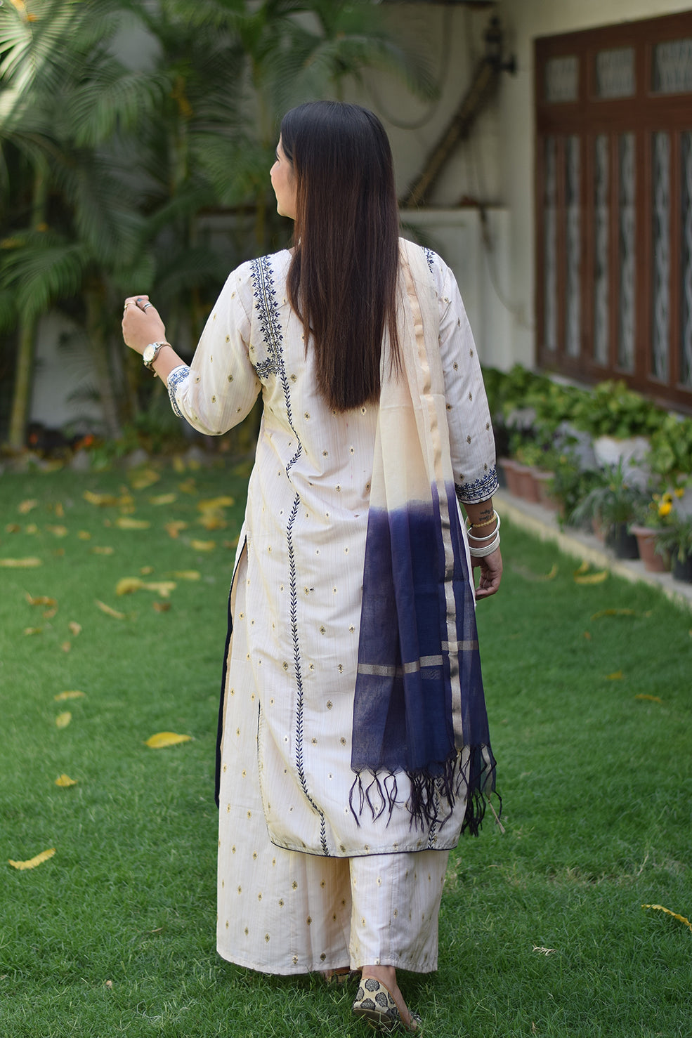 A fashionable Indian woman wearing an Off-White Silk Kurta with intricate embroidery.