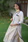 A chic Indian woman in a fitted Off-White Silk Kurta paired with leggings.