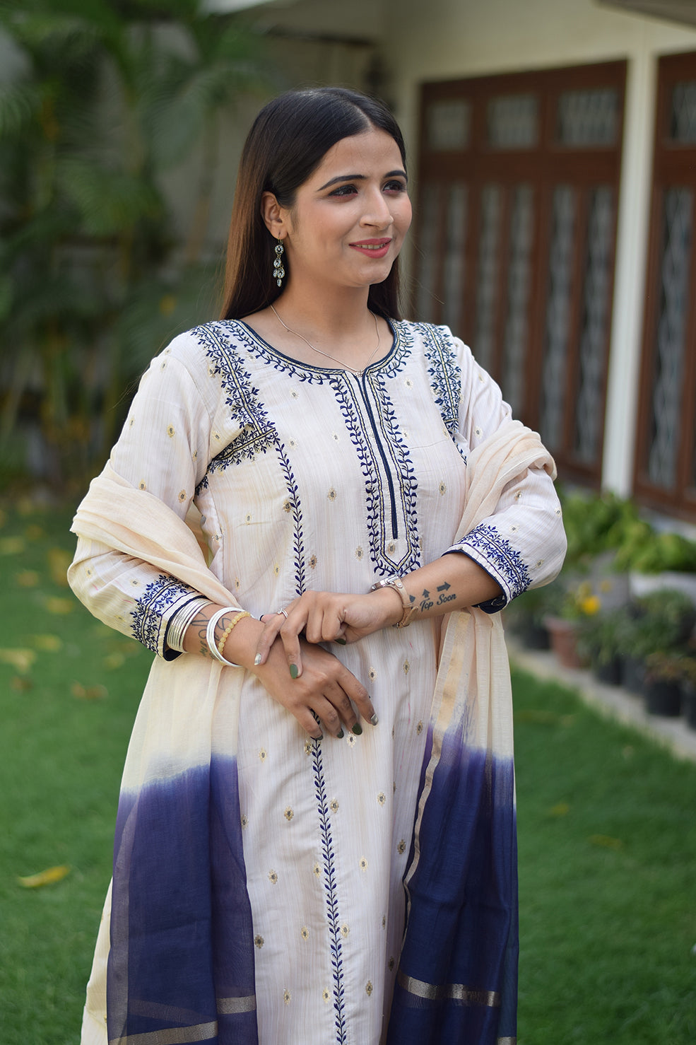 A radiant Indian woman wearing an Off-White Silk Kurta with a high neckline and delicate detailing.