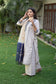 A stylish Indian woman dressed in an Off-White Silk Kurta.
