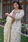 A chic outfit of a woman wearing a beige chanderi kurta and dupatta with wide-leg beige trousers.