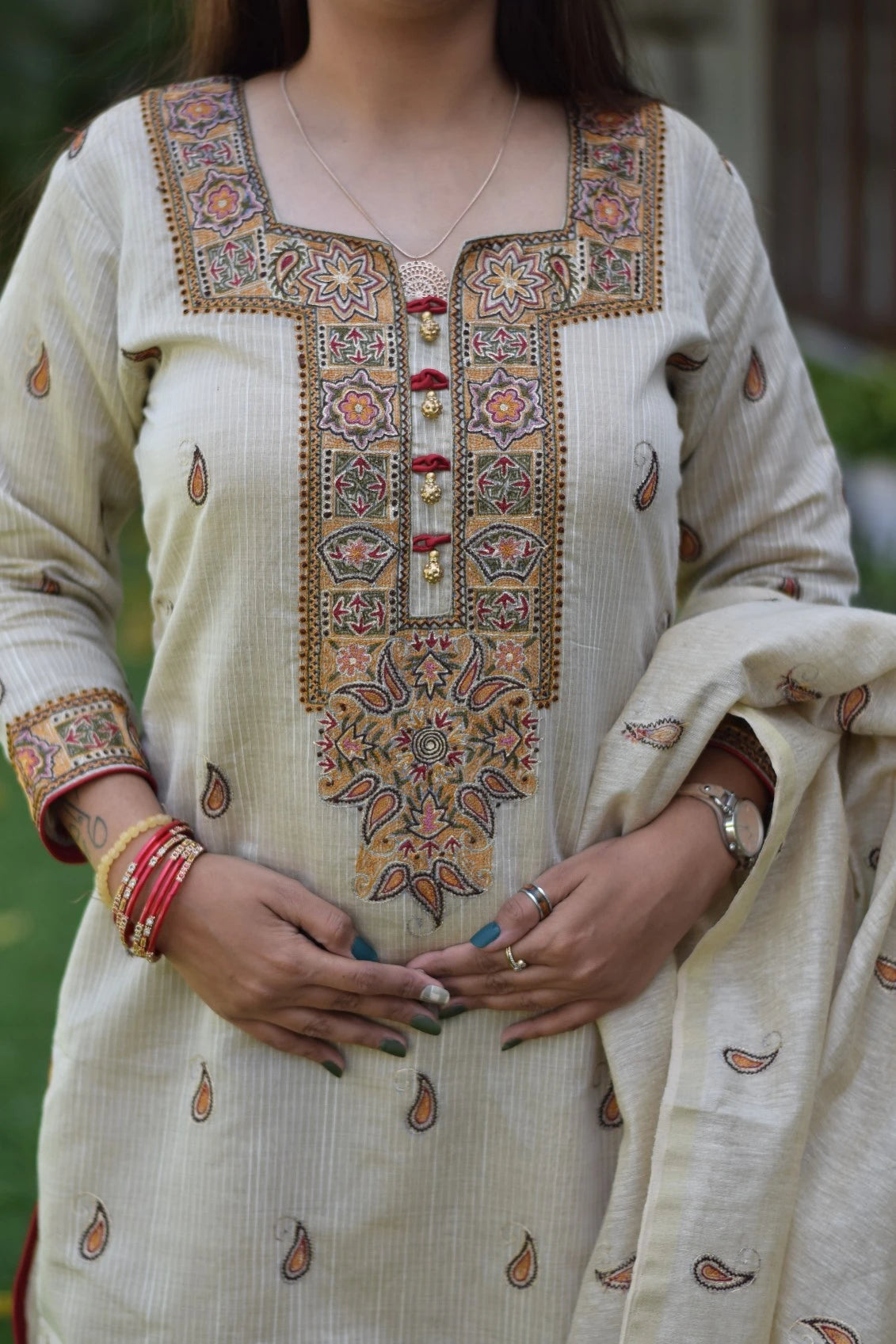 A classic look of a woman wearing a beige chanderi kurta and dupatta with straight beige trousers.