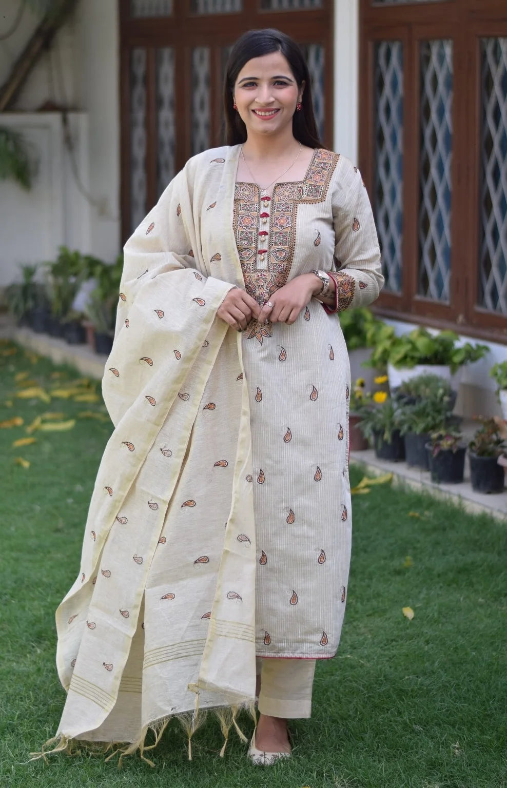 A close-up of the hand embroidery on a beige chanderi kurta worn by a woman.