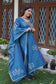 A young Indian woman looking charming in a blue applique work suit.