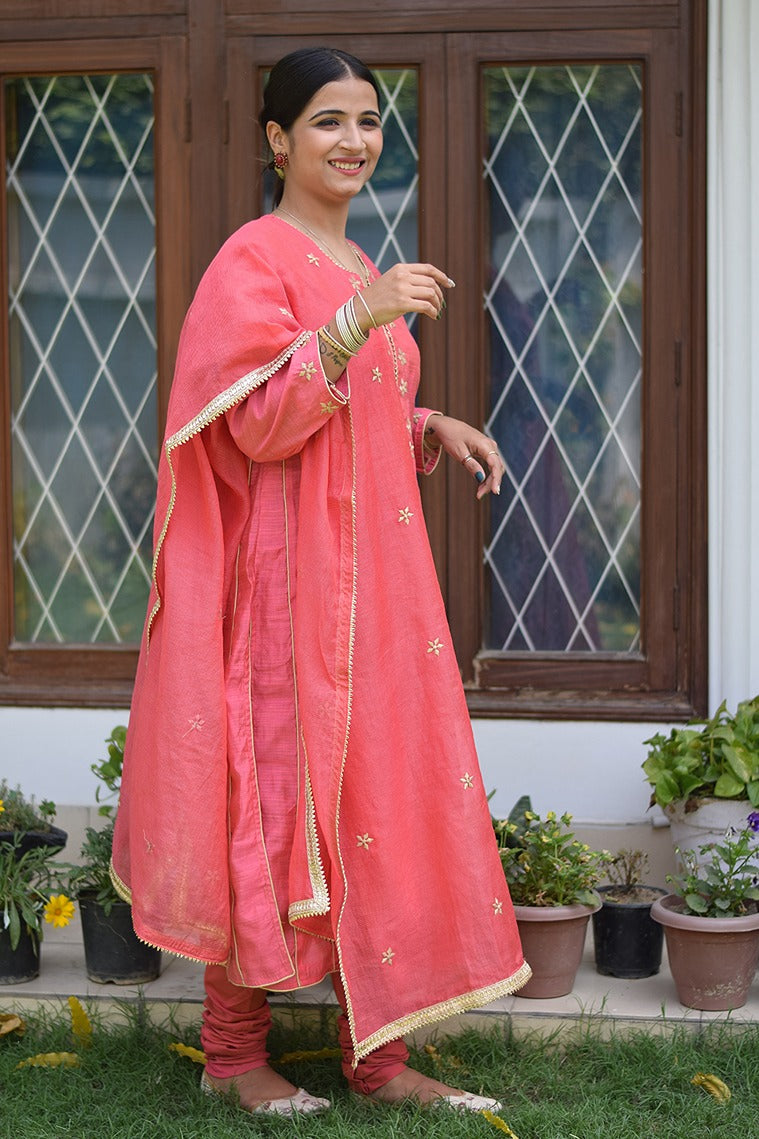 A lovely lady dressed in a traditional pink jute kurta with churidar.