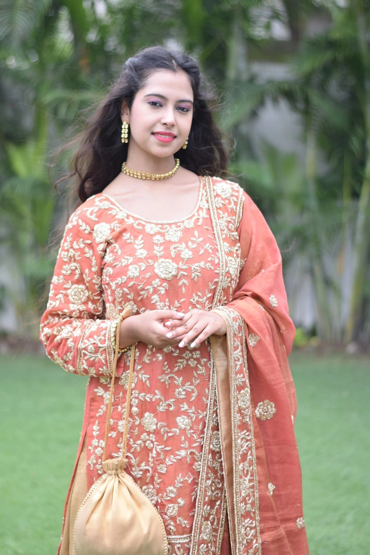 A stunning woman wearing a farshi gharara in golden rust.