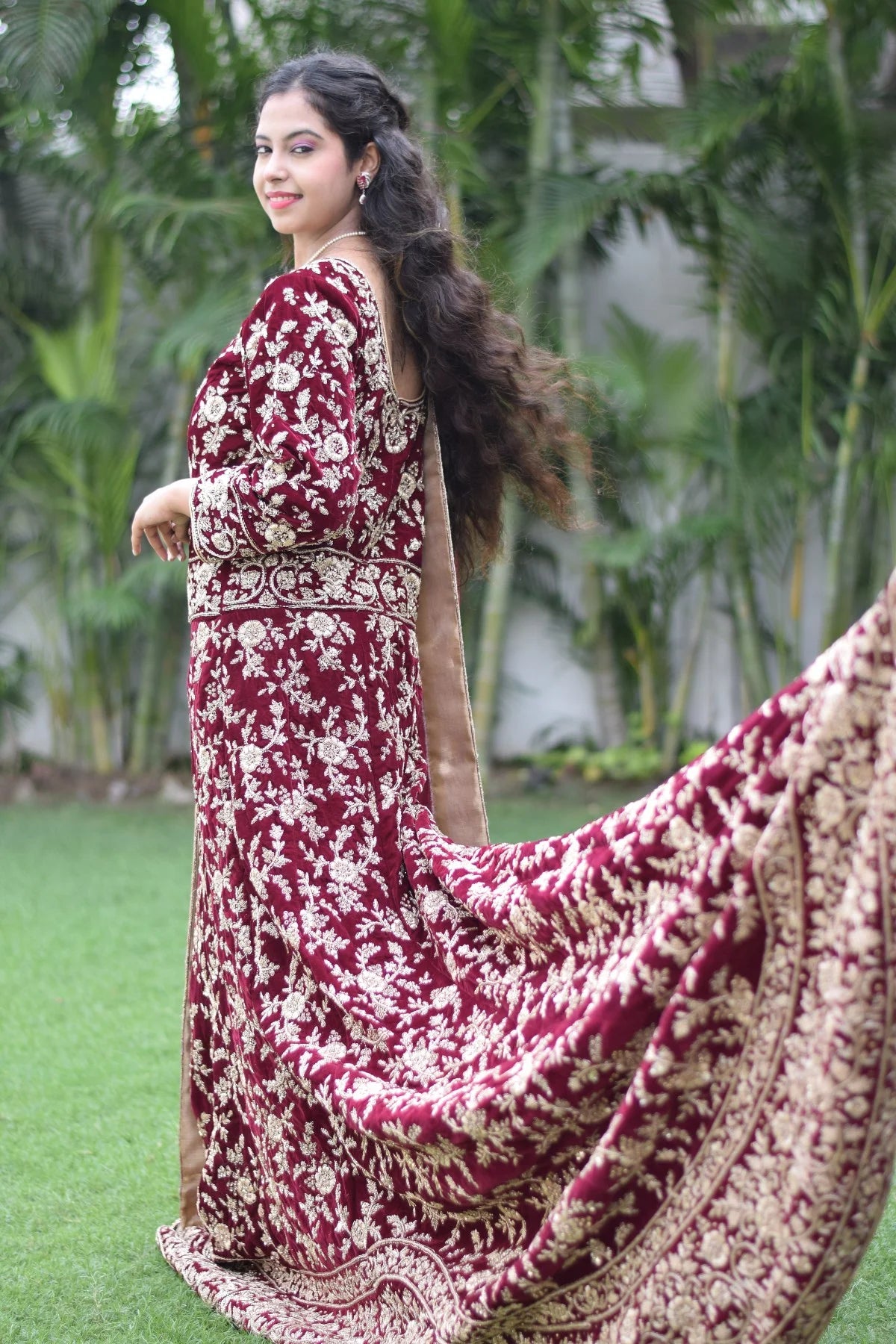 This Indian woman looks regal in her maroon Trail Gown, featuring a unique blend of modern and traditional elements.