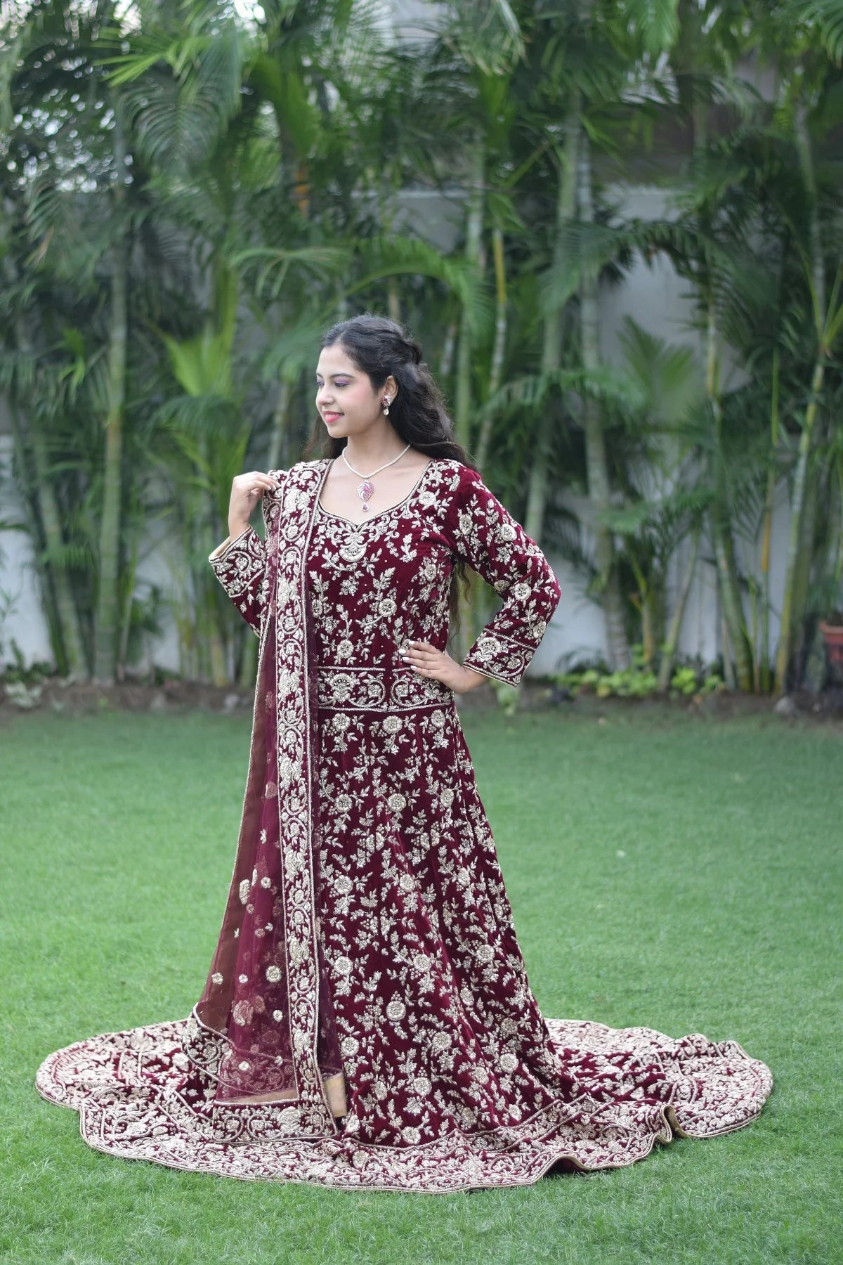 This Indian woman's confidence shines through in her maroon Trail Gown, a perfect blend of traditional Indian fashion and modern sensibility.