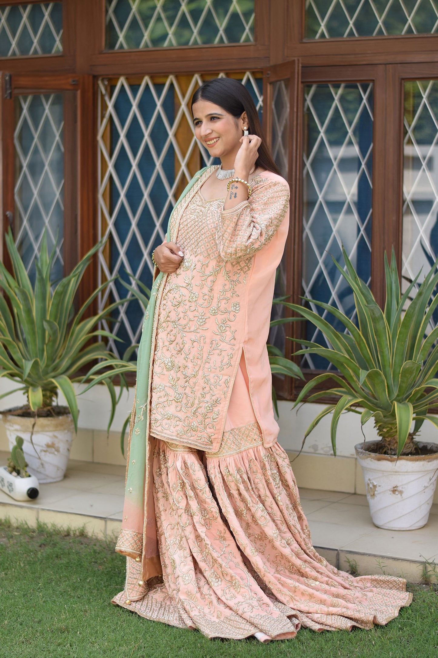 Stylish ensemble featuring Woman in Peach Crepe Silk Zardozi Jaal Work Gharara Set