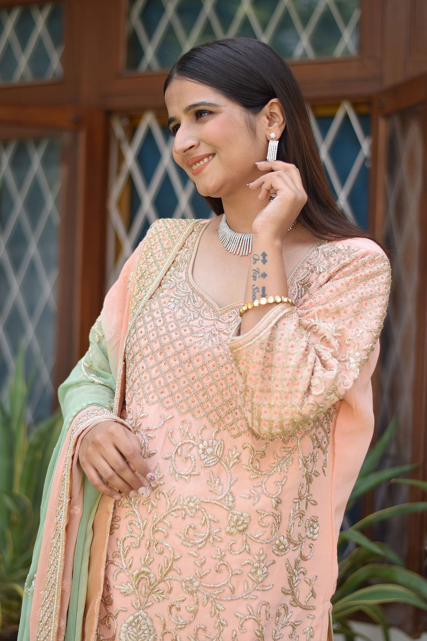 Graceful lady dressed in Peach Crepe Silk Zardozi Jaal Work Gharara Set