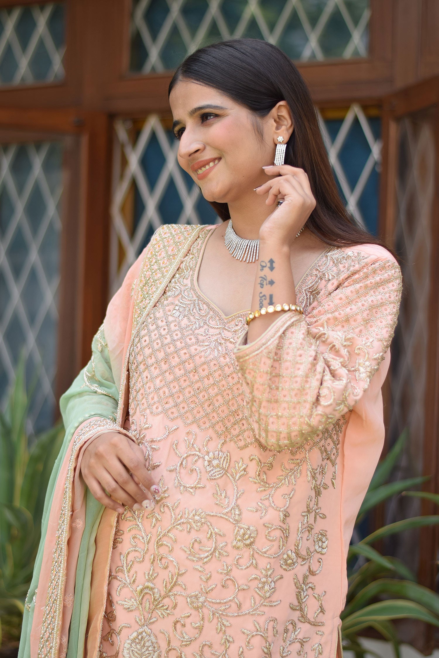 Graceful lady dressed in Peach Crepe Silk Zardozi Jaal Work Gharara Set