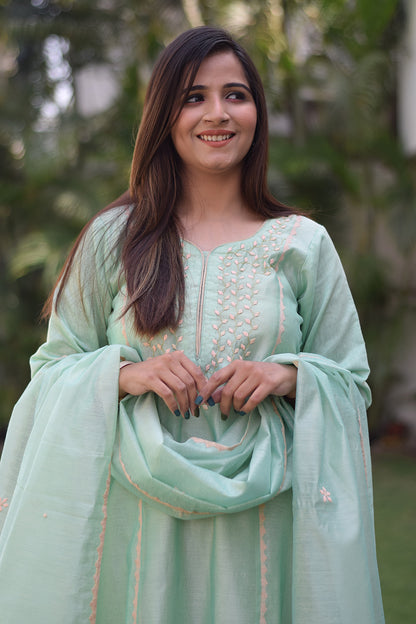An elegant Indian woman in a sea green Aari work kurta with intricate sequin work