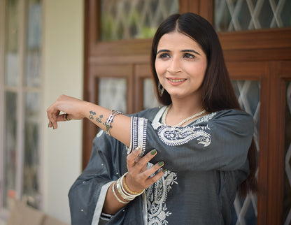 An ethnic Indian woman wearing a grey kurta and dupatta.