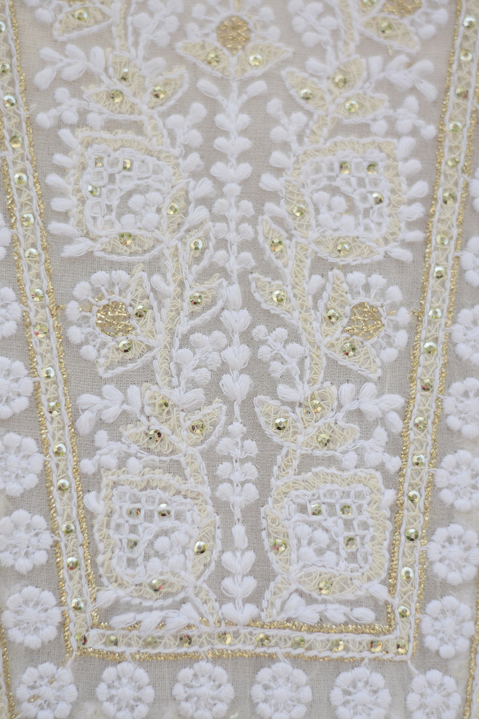 A close-up of a white georgette dupatta featuring intricate chikankari embroidery with delicate kikri and kamdani work.