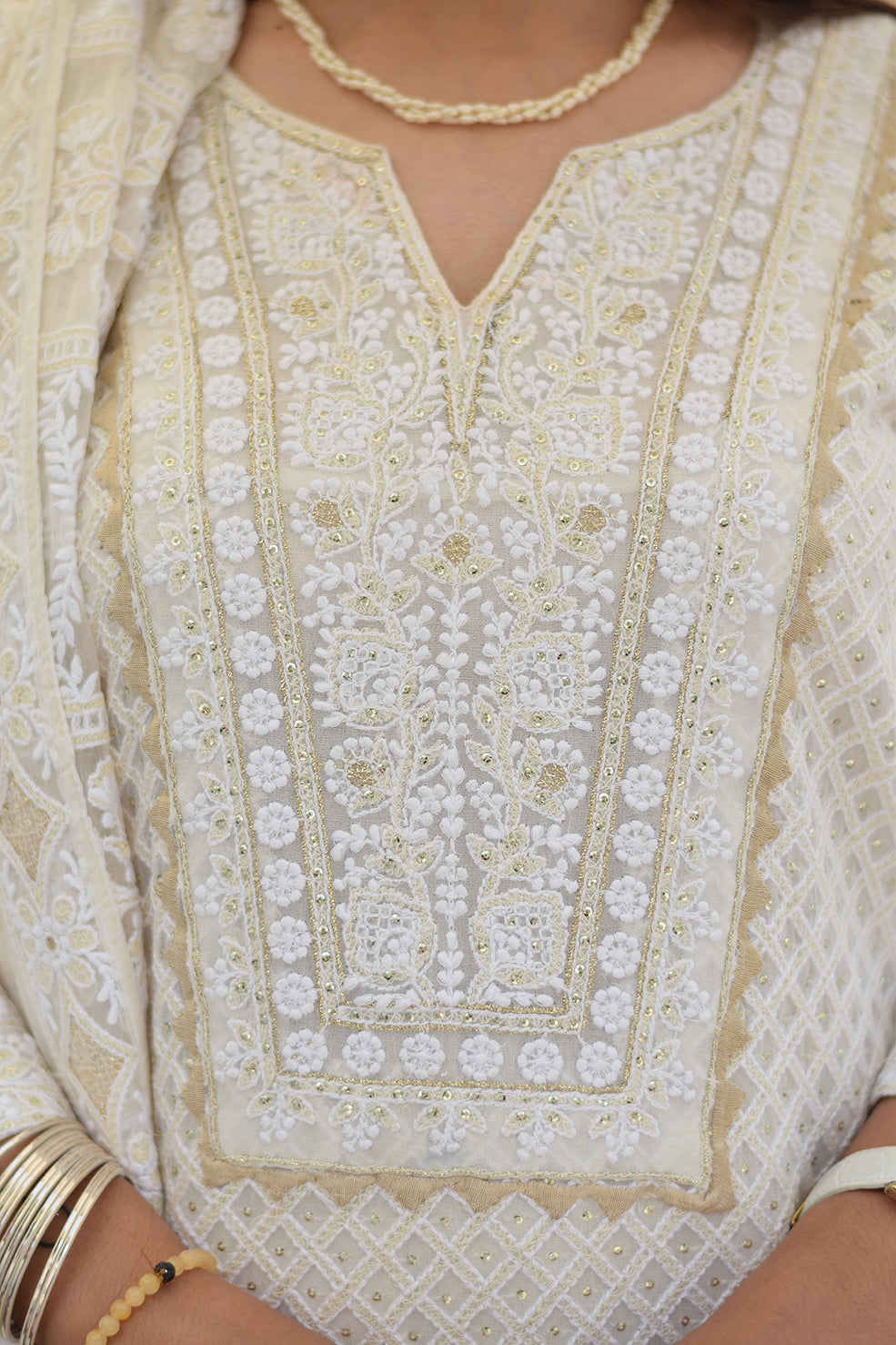 Close-up of the intricate chikankari embroidery, featuring kikri and kamdani details, on a white georgette kurta