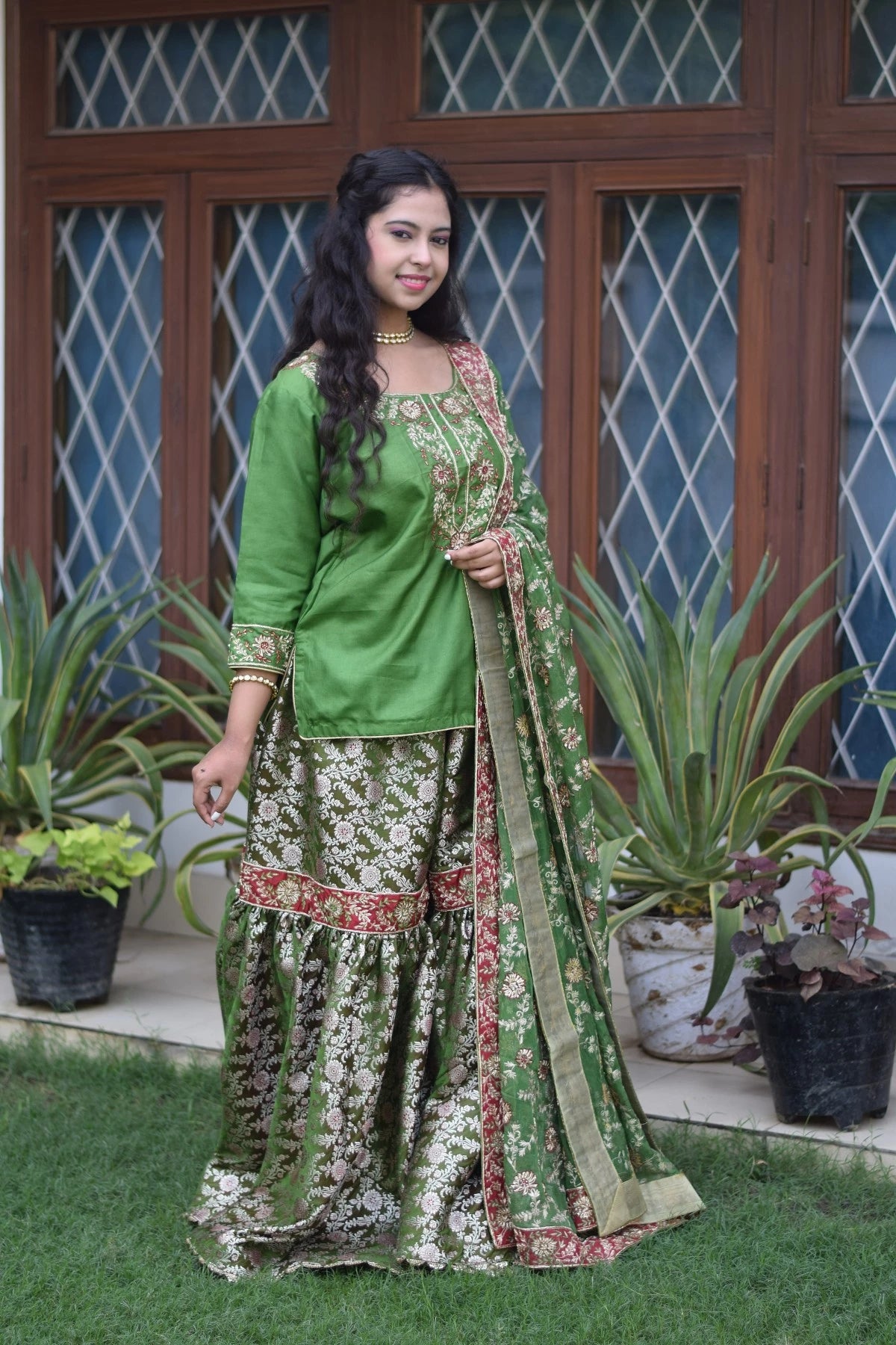 A bride dressed in a gorgeous green silk and kamkhab zardozi embroidery ensemble.