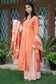A fashionable woman dressed in a stunning orange silk kurta and trousers