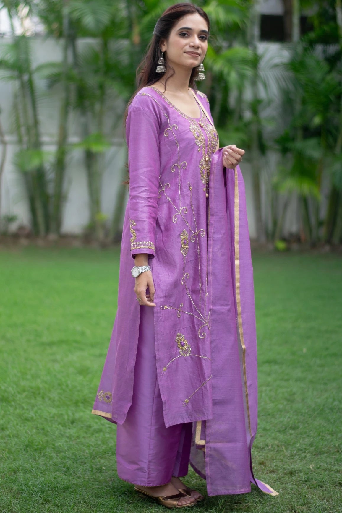 A striking image of a woman wearing a bold purple lilac kurta and comfortable trousers.