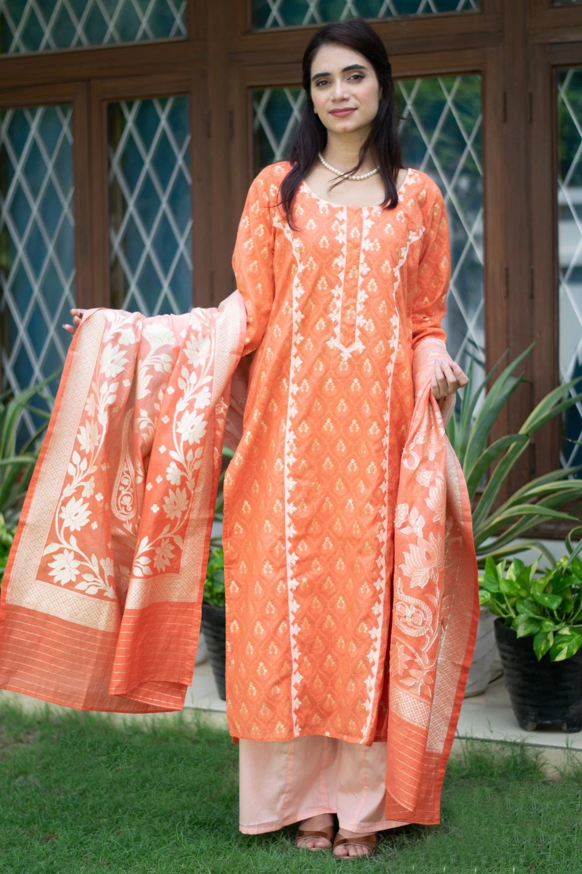 An image of a woman in traditional attire donning a silk kurta and trousers