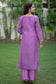 The focus of this image is a woman wearing an eye-catching purple lilac kurta and trendy trousers.