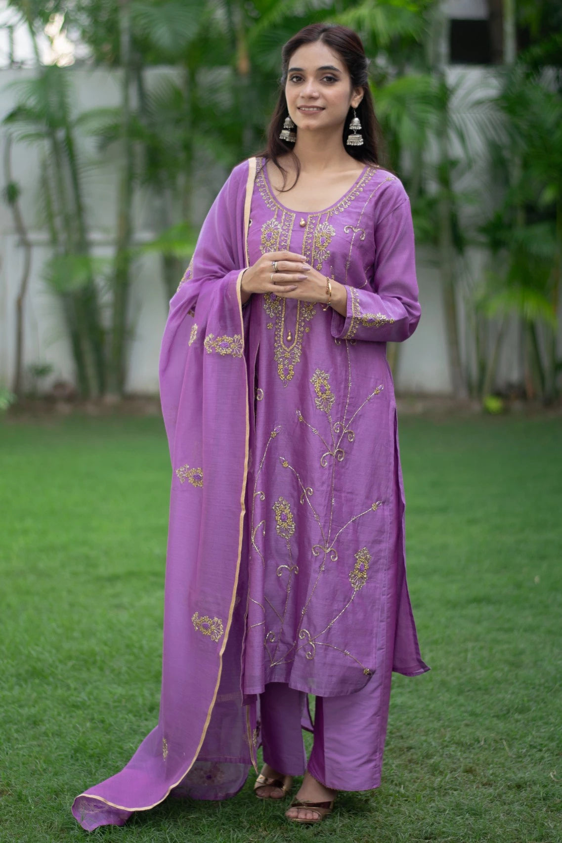 This image depicts a woman dressed in a vibrant purple lilac kurta with loose-fitting trousers.